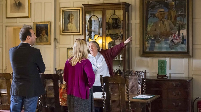 Visitors talking to a room guide at Benthall Hall, Shropshire. The house is situated on a plateau above the gorge of the River Severn.